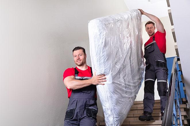 tackling the task of transporting a box spring out of a building in Mount Carroll IL